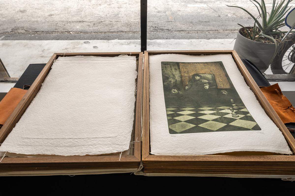 Carpeta desplegada de “Las naves quemadas”, 1992, de Facundo Fierro. En caja estuche en madera piel y tela, papel pergamino, 10 grabados al aguafuerte y aguatinta, sobre papel Meirat 350 gramos, hecho a mano y diseñado expresamente para esta edición, montados sobre bastidores de madera de 26.7 x 19.6 pulgadas (68 x 50 cm) cada una. Tirada de 100 ejemplares.