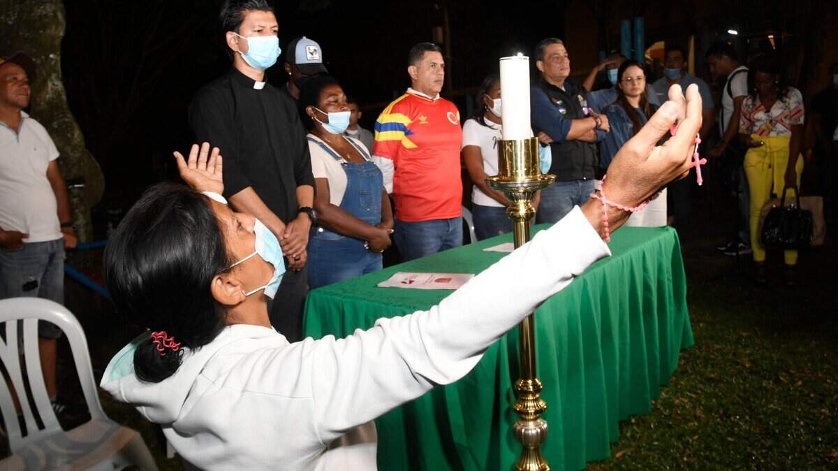Familiares y amigos de Freddy Rincón, quien resultó gravemente herido en un accidente de tránsito, oran por él durante una vigilia cerca del hospital donde está internado el exfutbolista en Cali, Colombia, el martes 12 de abril de 2022.