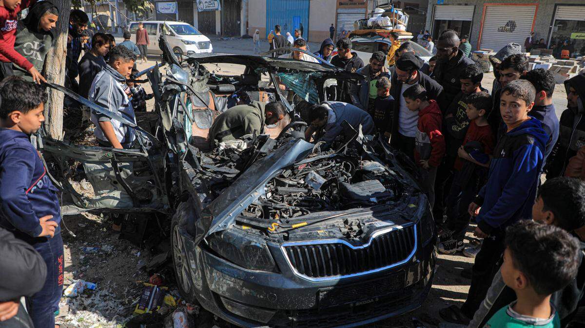 Una decena de personas rodea un auto que fue destruido por un ataque israelí, el domingo 7 de enero de 2024, en Rafah, sur de la Franja de Gaza. Dos periodistas que iban en el vehículo murieron y otro fue herido.