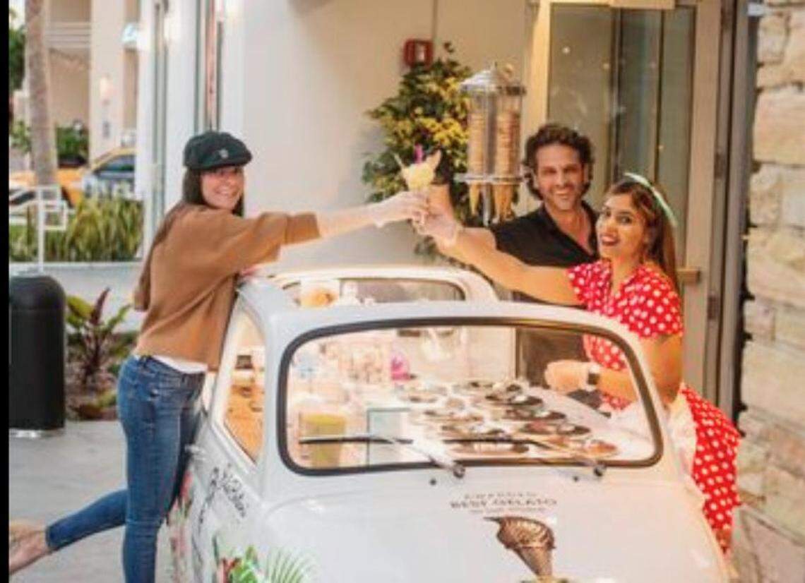 Alejandro Amador, al centro, en unos de los carritos Fiat  de su propiedad que vende gelatos. Amador está pidiendo un préstamo para mantener su negocio a flote.