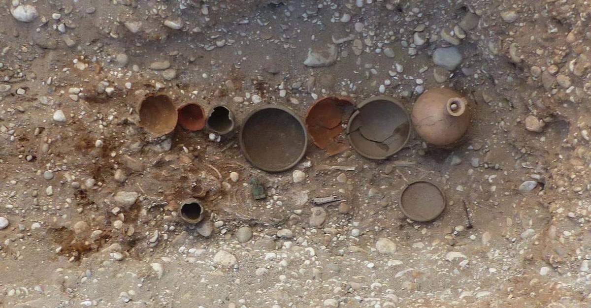 Colección de cerámicas, monedas, pulseras y depósitos de comida enterrados junto a un niño de entre uno y seis años. © Inrap