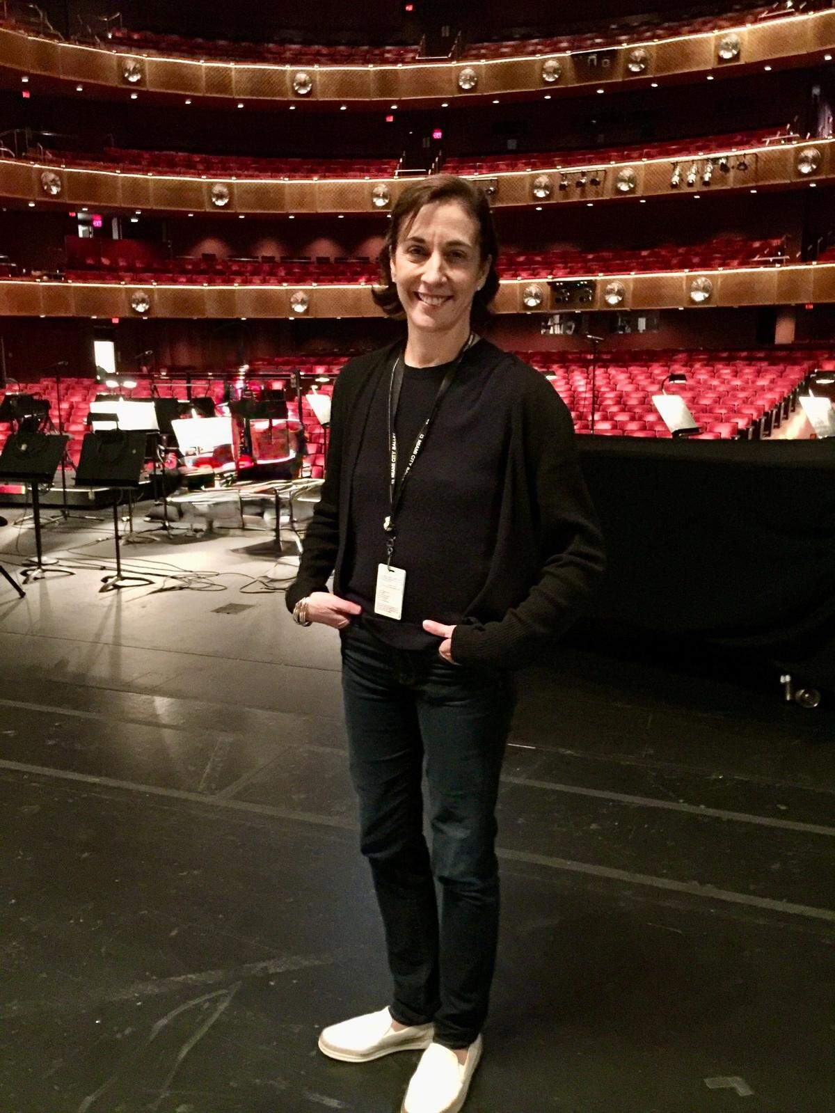 Lourdes López, en ropa de trabajo, sonriendo feliz en el escenario del Teatro Koch del Lincoln Center for the Performing Arts de Manhattan, durante la exitosa gira de MCB a Nueva York en 2016.