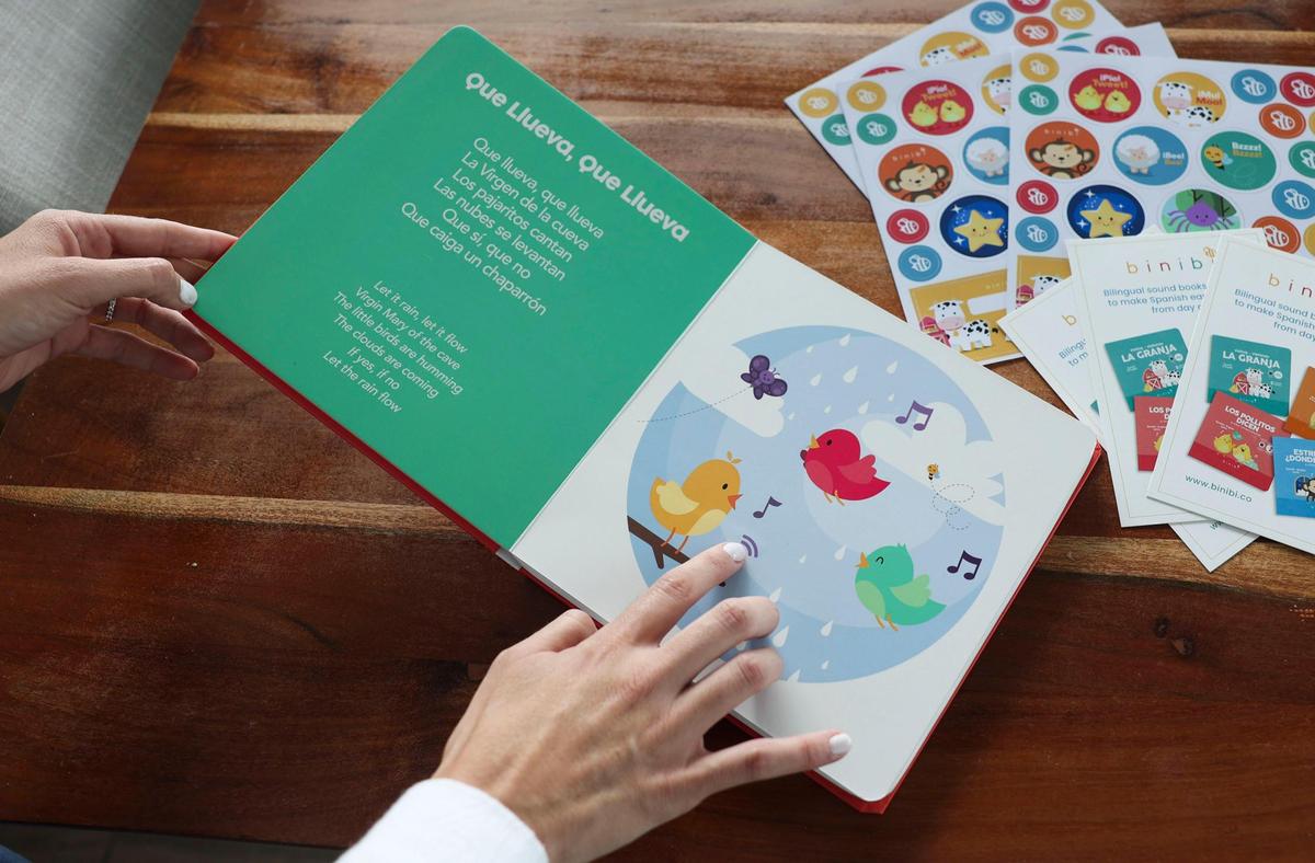 Ana Guzmán hojea Los Pollitos Dicen, su libro infantil más vendido, en la mesa de su cocina en Brickell el lunes 24 de octubre de 2022. Este libro tiene canciones que acompañan las palabras en inglés y español.
