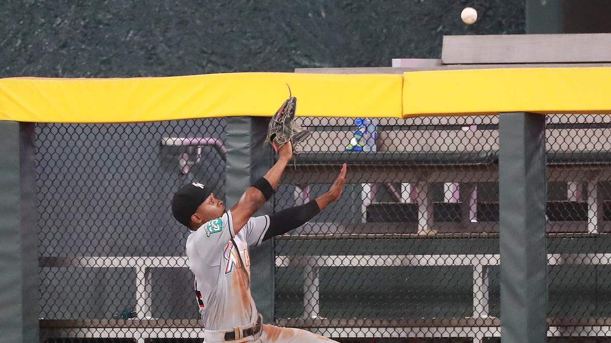El jardinero de los Marlins Magneuris Sierra salta pero no puede atrapar una pelota de jonrón bateada por Freddie Freeman en el sexto inning del partido ante los Bravos, celebrado el 14 de agosto de 2018 en Atlanta.