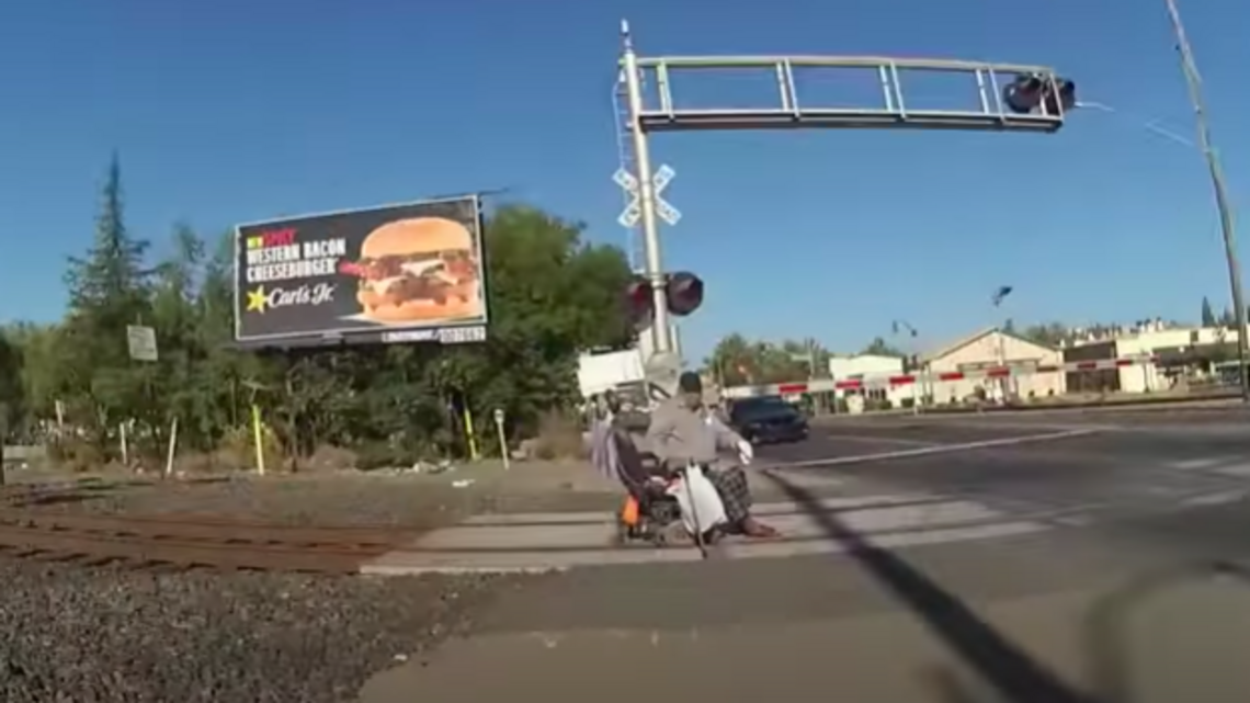 Video: policía salva a hombre en silla de ruedas atascado en las vías de un tren