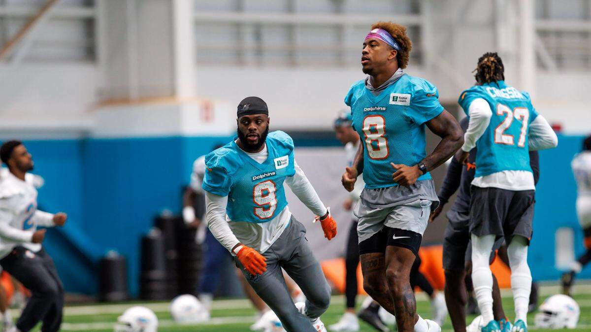 El safety de los Dolphins Jevon Holland (8) y el cornerback Noah Igbinoghene (9) corren en una práctica con el equipo el 14 de diciembre de 2022 en Miami Gardens, Florida.