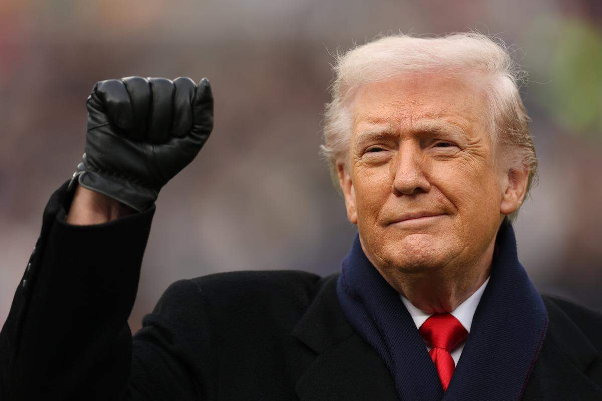 BALTIMORE, MARYLAND - DECEMBER 13: U.S. President Donald Trump acknowledges the crowd by raising his first before the 126th America's Game between the Army Black Knights and the Navy Midshipmen at M&T Bank Stadium on December 13, 2025 in Baltimore, Maryland. The teams are competing for the Commander-in-Chief's Trophy, with President Trump attending the rivalry for the second consecutive year. (Photo by Patrick Smith/Getty Images)
