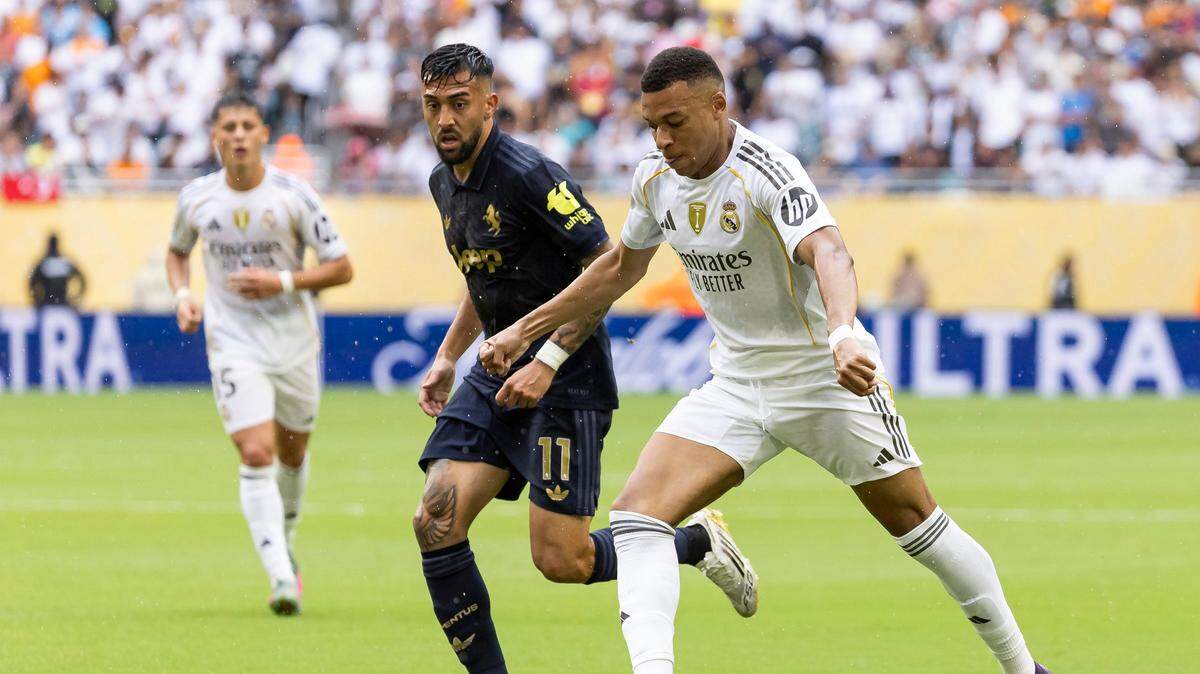 El delantero del Real Madrid Kylian Mbappé (der.) conduce la pelota ante la marca de Nicolás González, de Juventus, 
en el partido de octavos de final del Mundial de Clubes celebrado el 1ro de julio de 2025 en el Hard Rock Stadium en Miami Gardens, Florida.