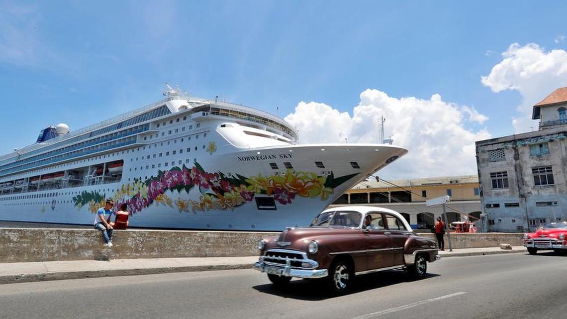 Classic cars pass in front of U.S. cruise ships at the port of Havana.