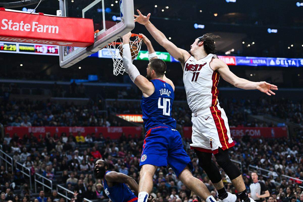 El jugador del Heat de Miami  Jaime Jáquez Jr. (der.) no puede impedir que el centro de los Clippers Ivica Zubac encestara una canasta, en el partido celebrado el 1ro de enero de 2024 en Los Angeles.