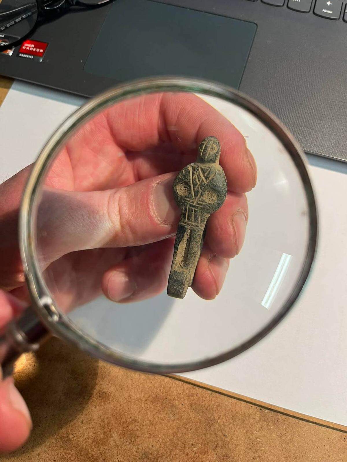 Un primer plano de la pequeña figura humana tallada en madera.