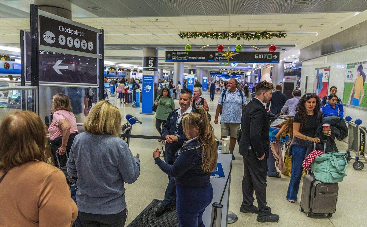 Personal del Aeropuerto Internacional de Miami guía a viajeros en la Terminal D del  MIA el viernes 21 de noviembre de 2025.
