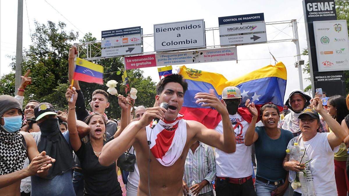 Un grupo de personas reaccionan en el lado colombiano de la frontera luego de ser atacados por el ejército de Nicolás Maduro, mientras intentaban moverse en varios camiones cargados con ayuda humanitaria para Venezuela a través del puente internacional Simón Bolívar, el 23 de febrero de 2019.