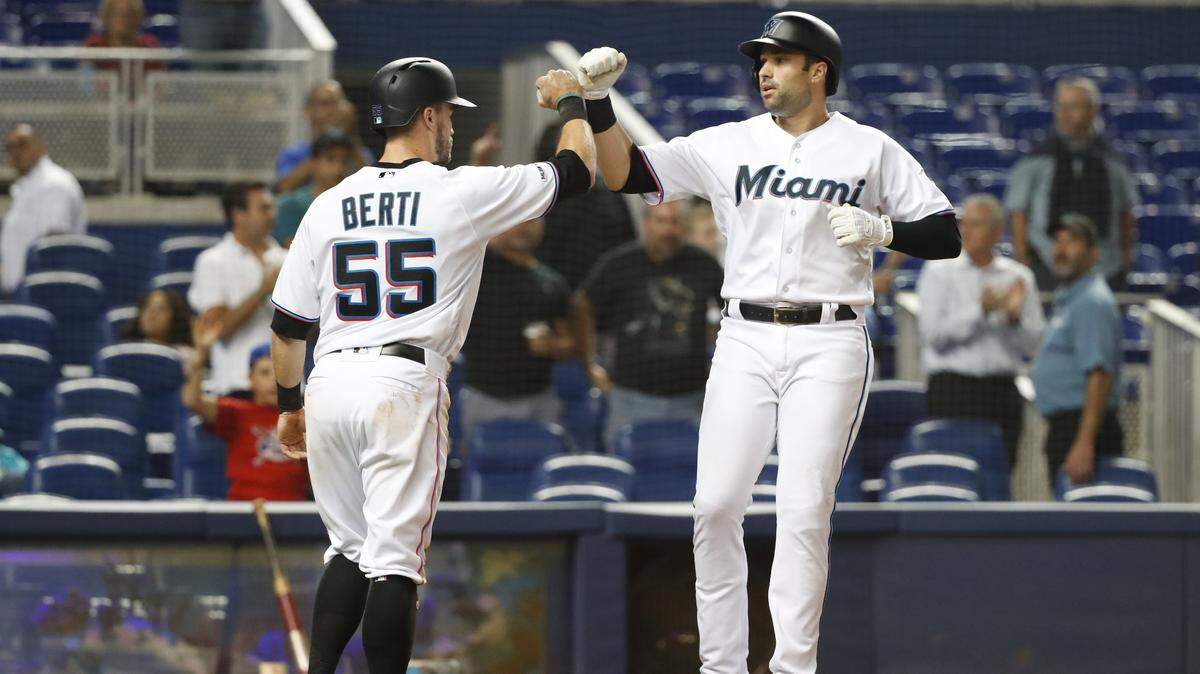 El tercera base de los Marlins Neil Walker (der.) recibe el saludo de Jon Berti tras pegar un jonrón en el tercer inning del partido ante los Rojos de Cincinnati, celebrado el 26 de agosto de 2019 en Miami.