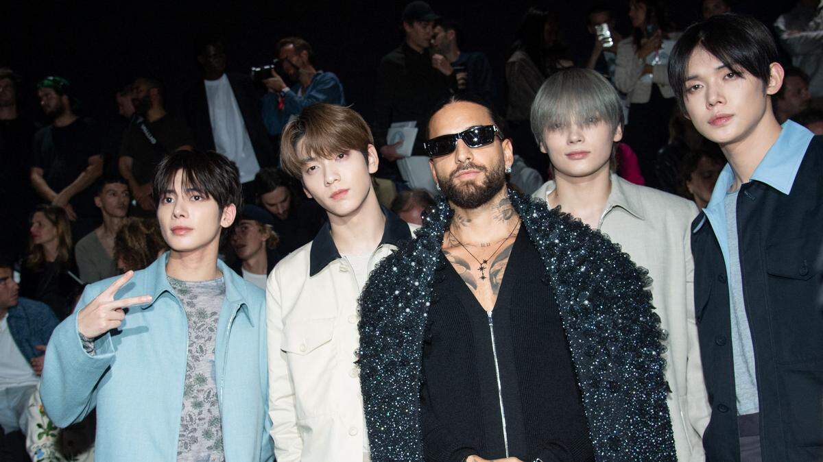El cantante colombiano Maluma (centro) posa con los integrantes de la banda coreana Tomorrow X Together, en la semana de la moda en París, el 21 de junio de 2024.