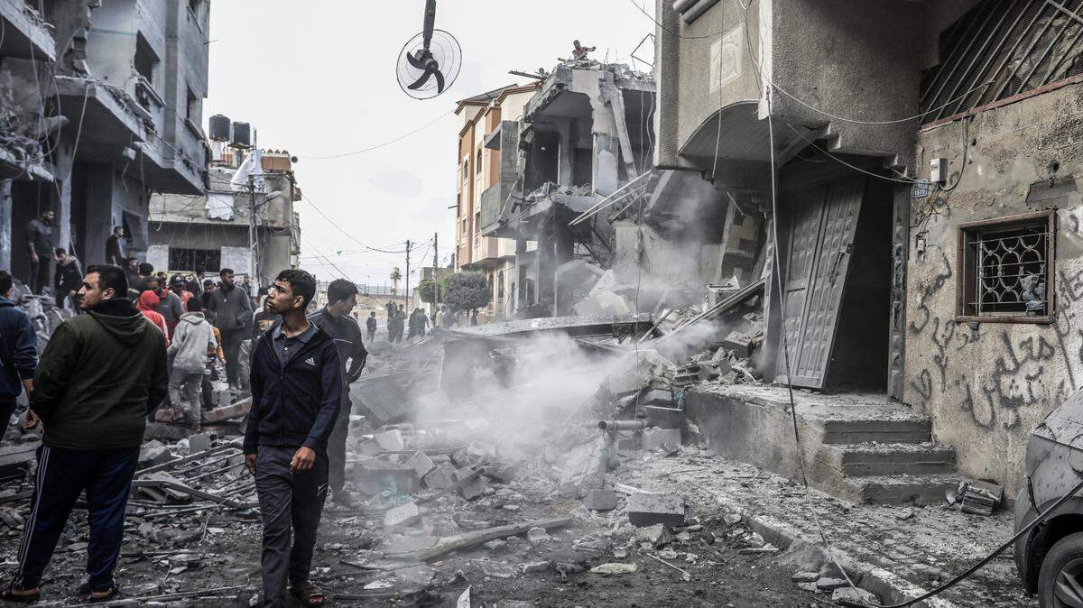 Palestinians inspect the rubble of a building following Israeli bombing amid ongoing battles between Israel and Hamas.