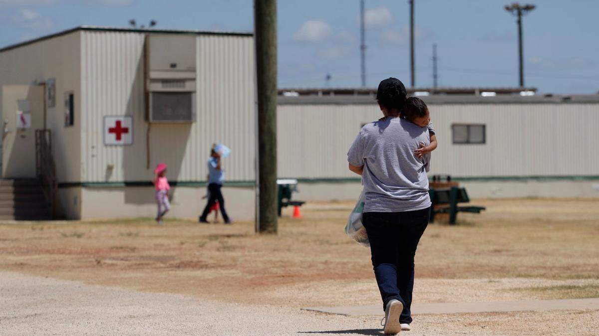 En esta foto de archivo del 23 de agosto de 2019, inmigrantes que buscan asilo caminan en el Centro Residencial Familiar ICE South Texas, en Dilley, Texas.