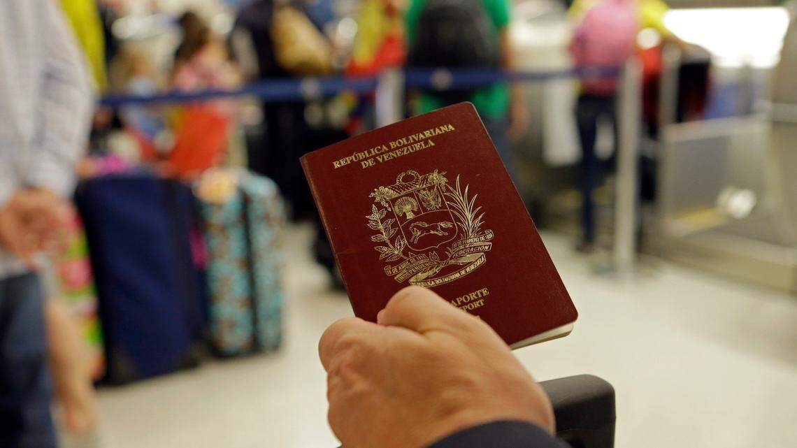 Un pasajero muestra su pasaporte venezolano en el Aeropuerto Internacional de Miami antes de viajar a Caracas. Foto de archivo.