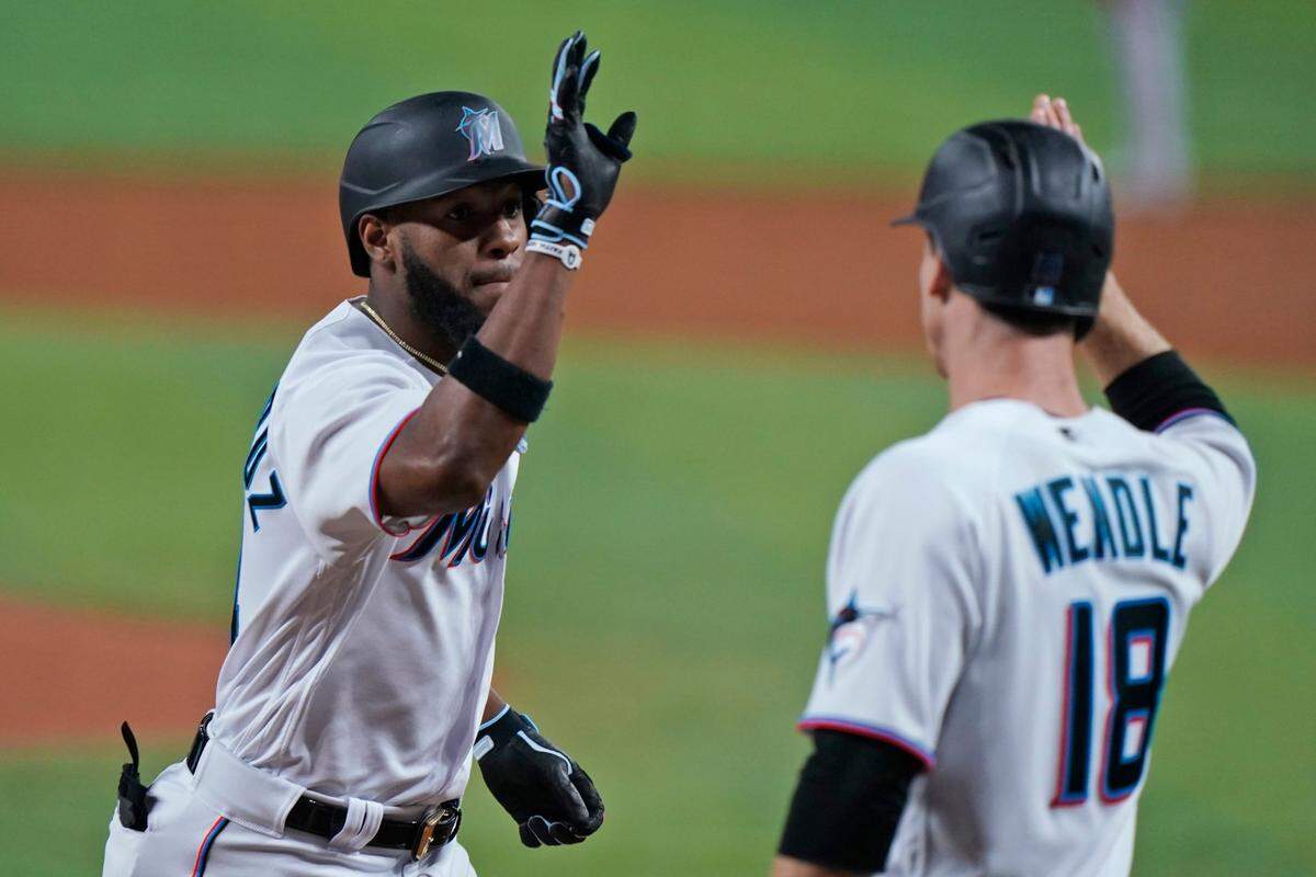 El jardinero de los Marlins Bryan De La Cruz (izq.) recibe el saludo de Joey Wendle tras pegar un jonrón en el tercer inning del partido ante los Bravos de Atlanta, celebrado el 3 de octubre de 2022 en Miami.