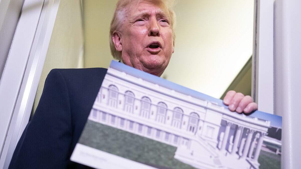 IN FLIGHT - MARCH 29: U.S. President Donald Trump holds a rendering of the proposed East Wing of the White House while speaking to members of the media onboard Air Force One on March 29, 2026 while en route to Joint Base Andrews, Maryland from West Palm Beach Florida. President Trump returned to Washington D.C. on Sunday following a weekend trip to Florida. (Photo by Nathan Howard/Getty Images)