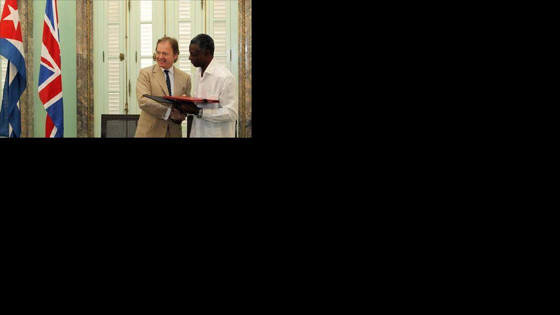 El secretario de Estado Británico de Exteriores, Hugo Swire (i), firma un acuerdo de cooperación con el vicepresidente primero del Instituto Nacional de Deportes, Educación Física y Recreación (INDER), Roberto León Richards (d), el jueves 30 de octubre de 2014, en La Habana (Cuba). EFE