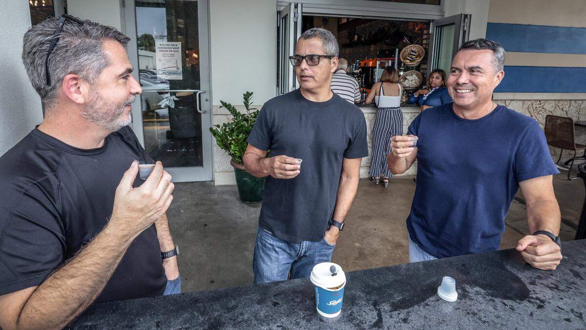 José Villafuerte, Ricky Guevara y Juan Silva comparten un cafecito afuera de la ventanita del restaurante Sergio’s en Kendall. 