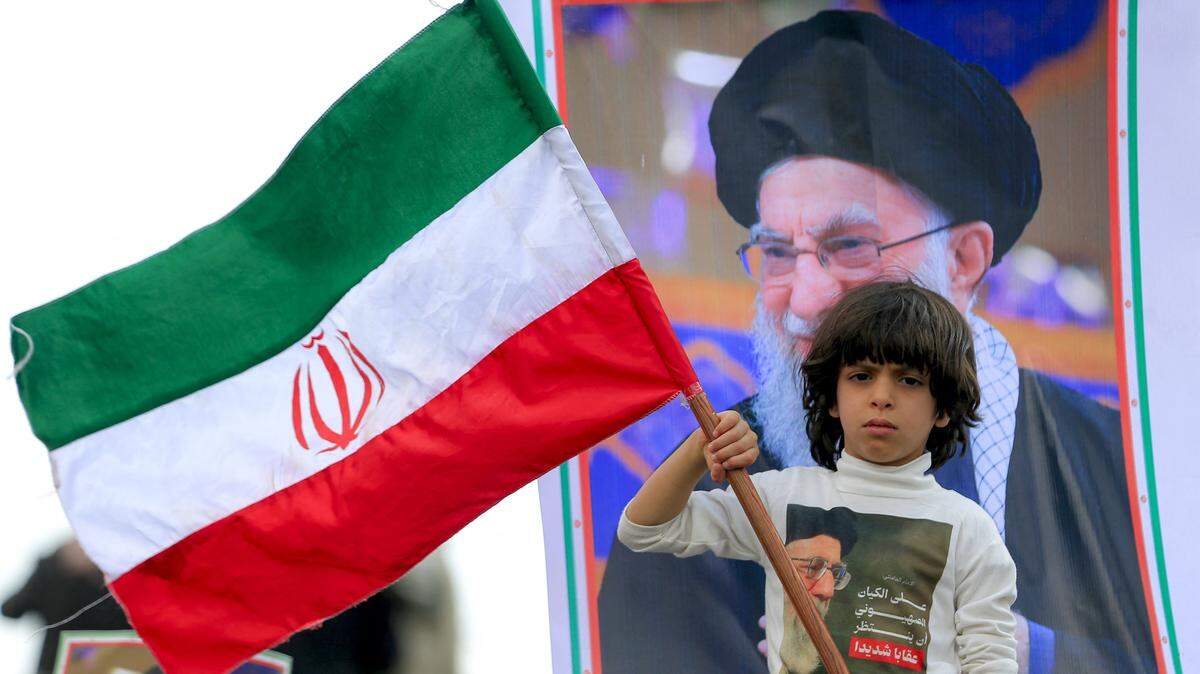 Un niño sostiene una bandera nacional de Irán frente a una imagen del líder supremo de Irán, Ali Khamenei, durante un mitin conmemorativo organizado por simpatizantes hutíes de Yemen, un día después de que Khamenei fuera asesinado durante ataques de Estados Unidos e Israel en Teherán, en la capital sanahí controlada por los hutíes, el 1 de marzo de 2026.