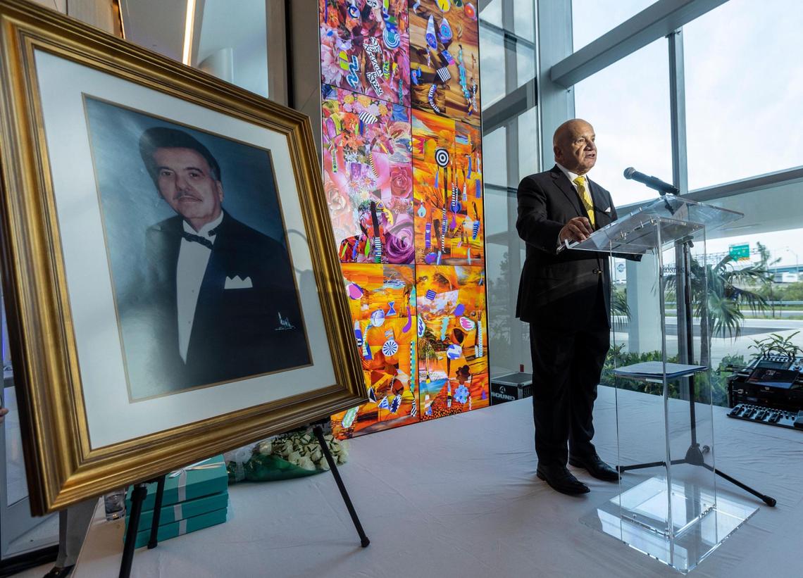 Alongside a portrait of the late José Milton, Carlos Migoya, CEO of Jackson Health System, speaks during a July 27, 2021, ceremony to inaugurate the new Jackson West Medical Center / José Milton Memorial Hospital at 2801 NW 79th Ave. in Doral.