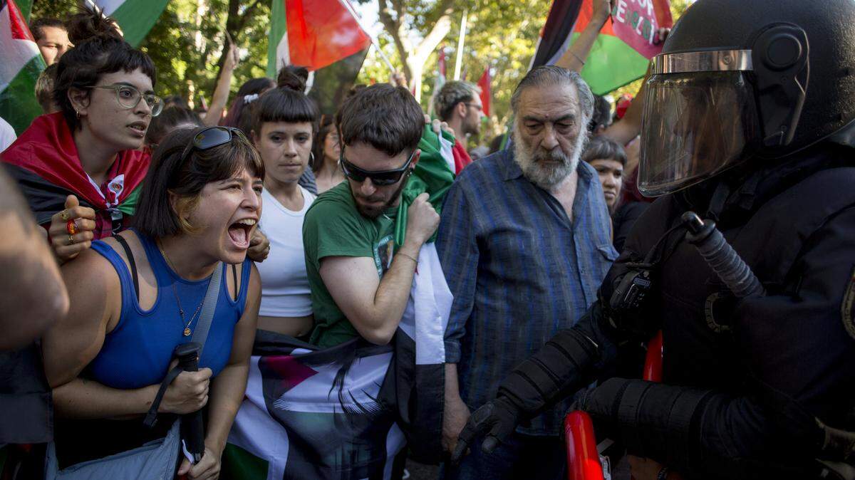 Manifestantes pro-palestinos gritan a un policía durante las manifestaciones tras la cancelación de la 21.ª etapa de la Vuelta Ciclista a España, el domingo 14 de septiembre de 2025. La 90.ª edición de la Vuelta Ciclista a España estuvo marcada por protestas en apoyo al pueblo palestino.