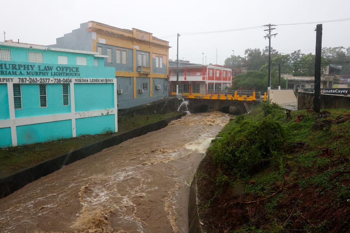 A river swollen by rains triggered by Hurricane Fiona runs through Cayey, Puerto Rico, Sunday, Sept. 18, 2022.