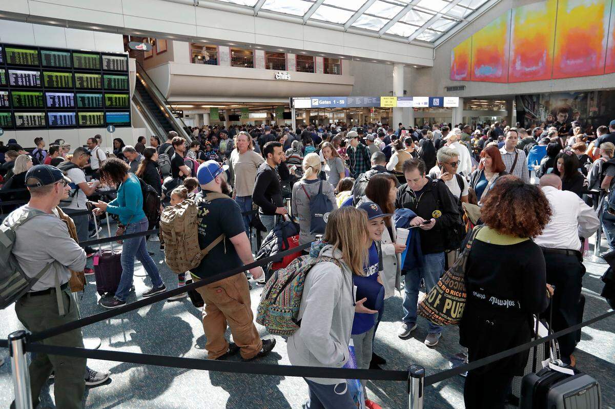 Viajeros hacen fila para pasar por los controles de seguridad en el Aeropuerto Internacional de Orlando el 21 de noviembre de 2018.