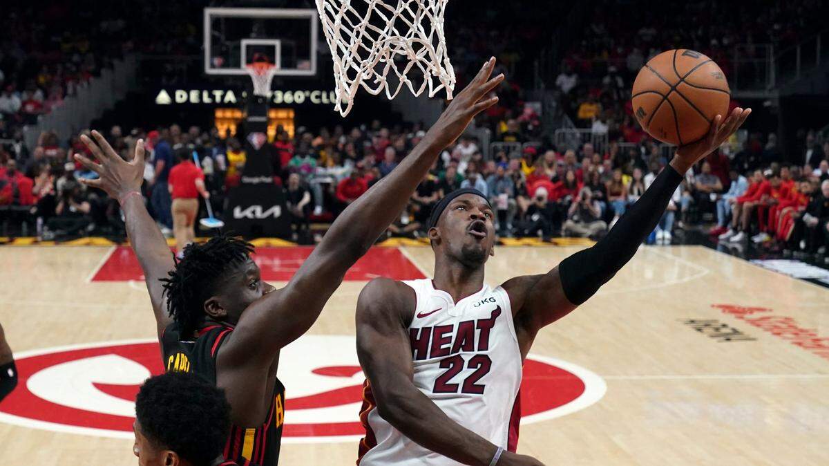 El jugador del Heat Jimmy Butler (22) tira al aro ante la marca de Clint Capela, de los Hawks, en el cuarto partido de la serie de primera ronda de los playoffs, celebrado el 24 de abril de 2022 en Atlanta.