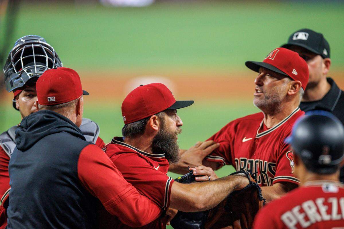 El abridor de los Diamondbacks de Arizona Madison Bumgarner es agarrado por los coaches del equipo tras discutir con el árbitro de primera base Dan Bellino, en el primer inning del partido celebrado el 4 de mayo de 2022 en Miami.