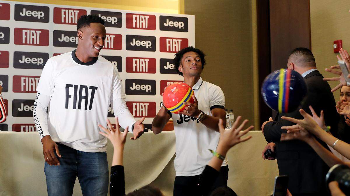 Los jugadores de la selección colombiana de fútbol, Yerry Mina (izq.) y Juan Cuadrado regalan balones durante una rueda de prensa el jueves 12 de julio de 2018, en Bogotá , Colombia.