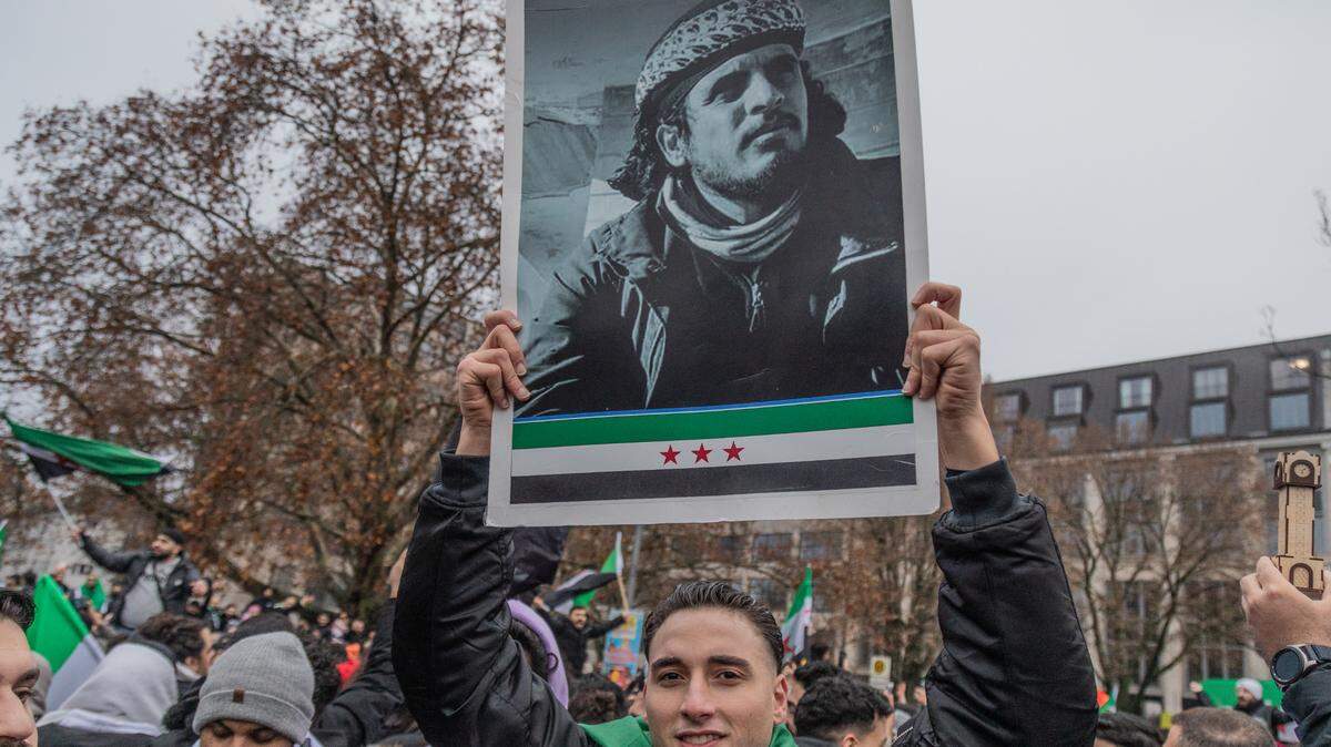 Un hombre sostiene una foto del líder de los rebeldes sirios, el islamista Abu Mohamed al Jolani, durante una protesta de celebración de miles de sirios en Berlín, Alemania, el domingo 8 de diciembre de 2024.