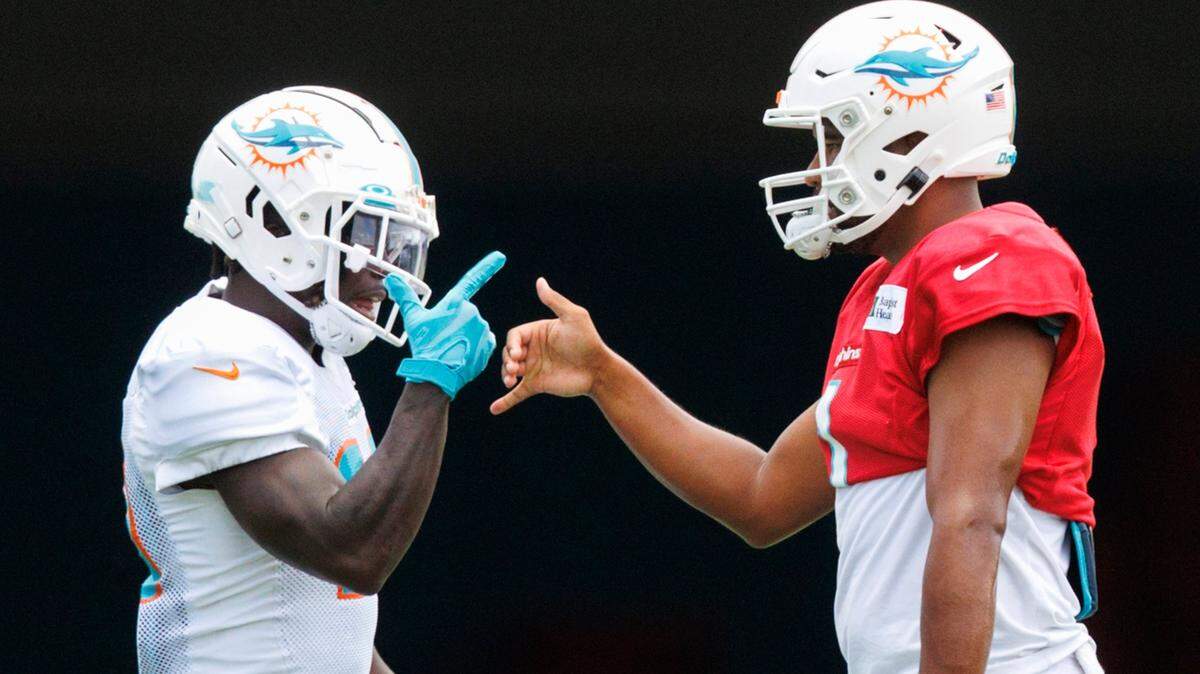 El quarterback de los Dolphins Tua Tagovailoa (der.) felicita al wide receiver Tyreek Hill después de una jugada en la práctica del equipo celebrada en el Baptist Health Training Complex en el Hard Rock Stadium, en Miami Gardens, Florida, el 7 de agosto de 2022.