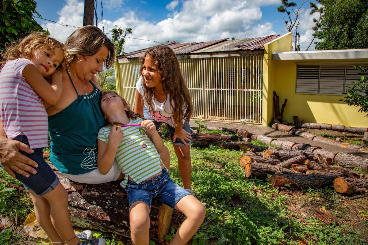 Eunice González Caro, de 56 años, regresó recientemente a su casa en Hato Nuevo, Gurabo, Puerto Rico, después que los daños causados por el huracán María la obligaron a marcharse al territorio continental estadounidense con su familia. De izquierda a derecha: sus nietas Yarisbel Mounique, de 5 años; Anabelle Marie, de 7, e Isabel Janice, de 8. Anabelle sufre de autismo y necesita un maestro auxiliar para poder estar en un aula regular.