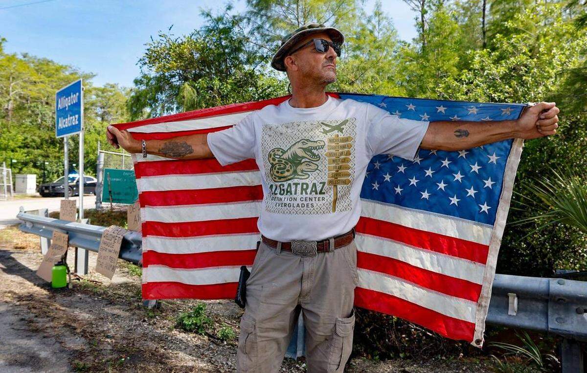 Mark Ribas, de Naples, un manifestante en apoyo al “Alcatraz de los caimanes”, se encuentra cerca de la entrada de la instalación de detención. Esta se ubica en los Everglades de Florida, a 36 millas al oeste del distrito financiero central de Miami, en el condado de Collier, Florida, el sábado 12 de julio de 2025. FOTO DE AL DIAZ adiaz@miamiherald.com