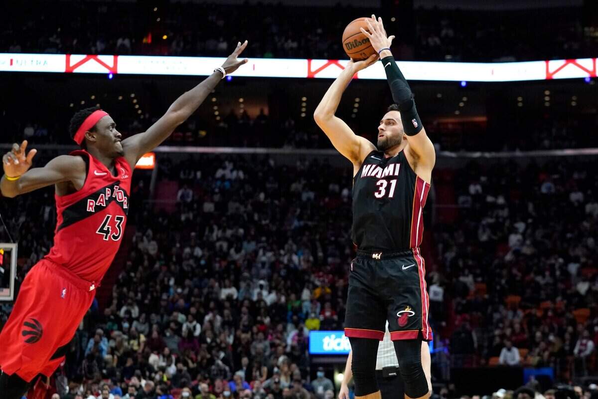 El jugador del Heat Max Strus tira al aro ante la marca de Pascal Siakam, de los Raptors, en el partido celebrado el 1ro de febrero de 2022 en Toronto.