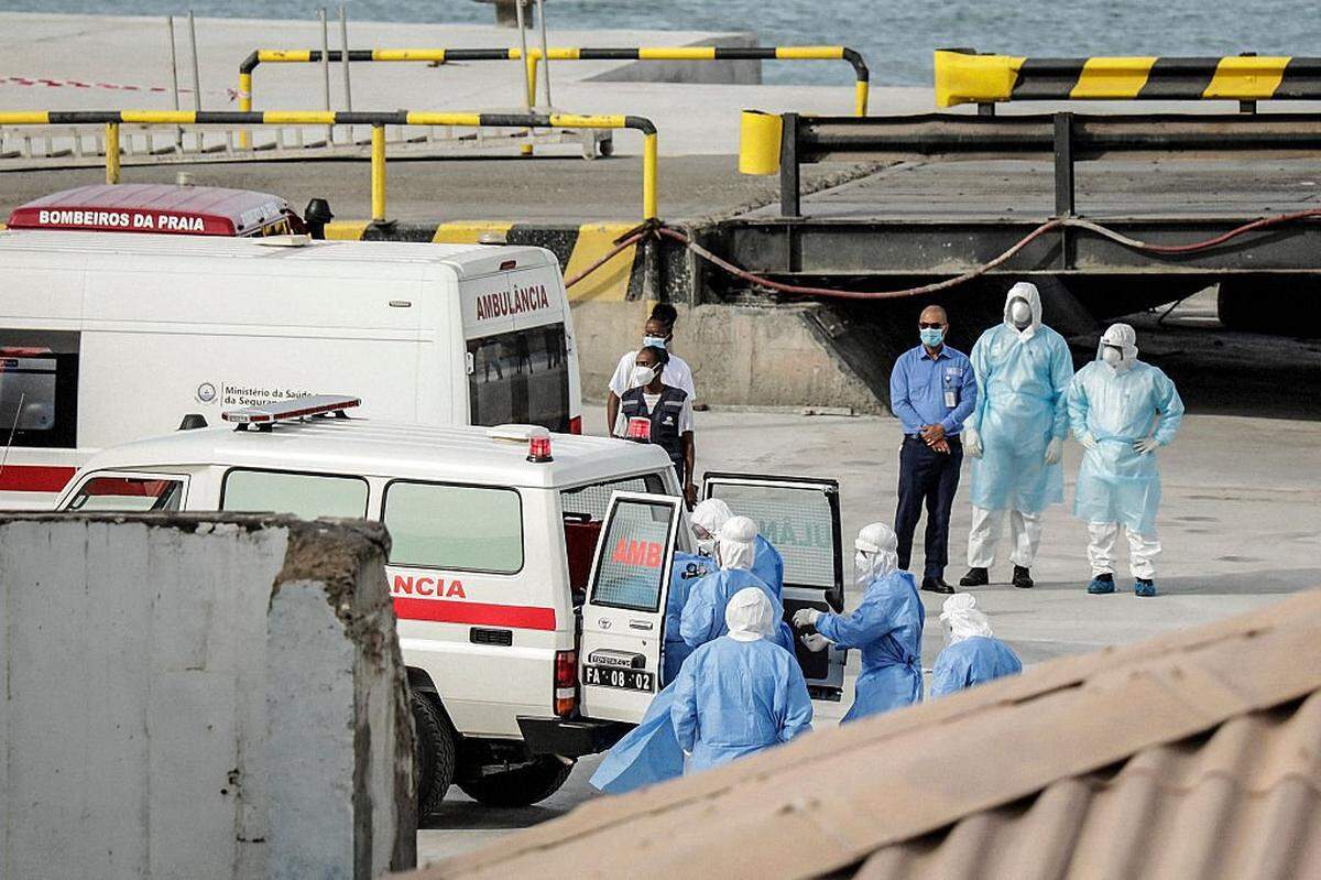 Se observa a personal sanitario que regresa del crucero MV Hondius en el puerto de Praia, la capital de Cabo Verde, mientras se ayuda a subir a una ambulancia a varias personas ataviadas con trajes de protección biológica, el 6 de mayo de 2026.