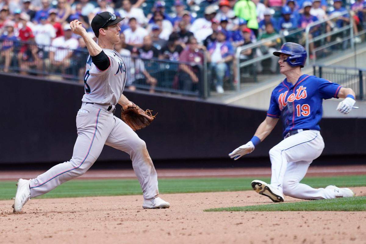 El segunda base de los Marlins Joey Wendle tira a primera base en una jugada de doble matanza que puso out a Mark Canha, de los Mets, celebrado el 10 de julio de 2022 en Nueva York.