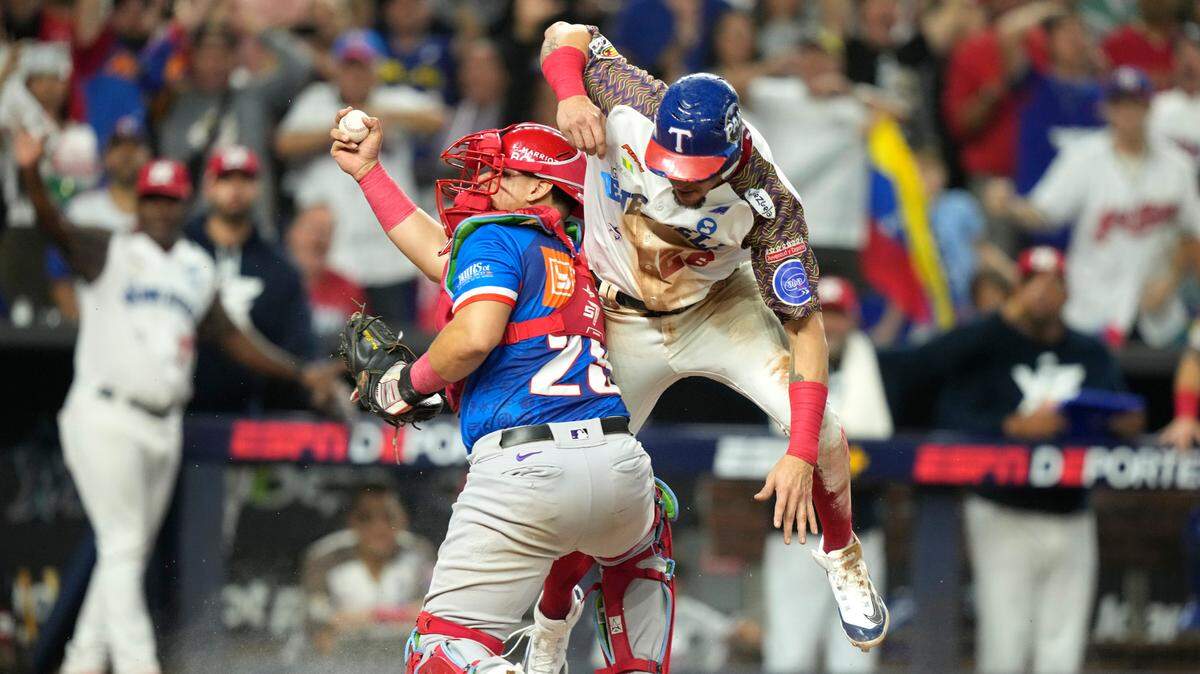El receptor puertorriqueño Jonathan Morales sostiene la pelota en una jugada en el plato con el venezolano Hernán Alejandro Pérez, en la segunda entrada del partido de la Serie del Caribe, celebrado el domingo 4 de febrero de 2024 en Miami.