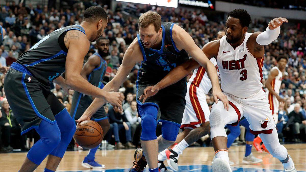 Dirk Nowitzki (centro) lleva la pelota por los Mavericks ante la marca de Dwyane Wade, del Heat, en el partido celebrado el 13 de febrero de 2019 en Dallas.