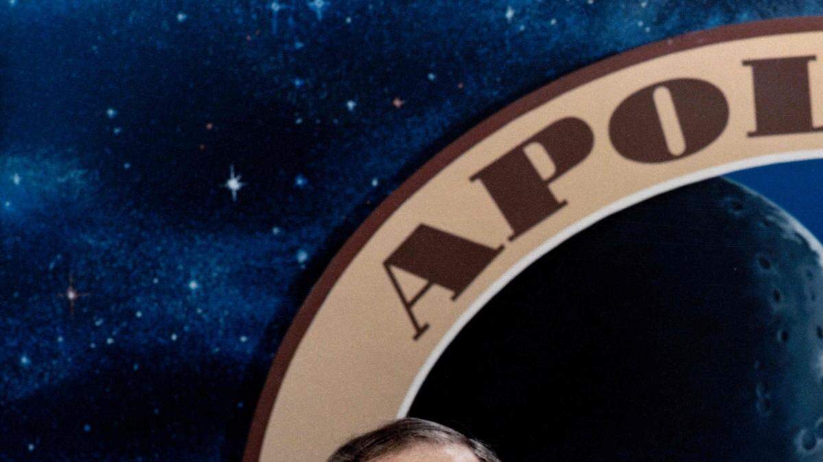 El astronauta Edgar D. Mitchell, posa frente a un gráfico de la misión Apolo 13. 