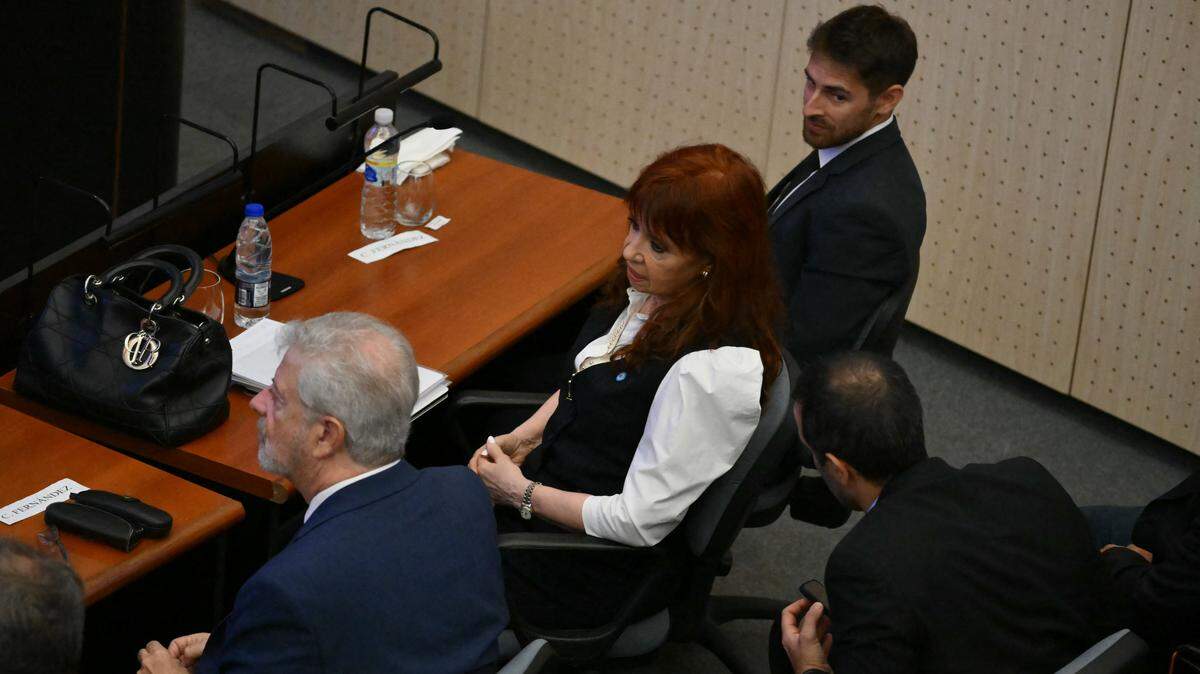 La expresidenta argentina (2007-2015) Cristina Kirchner (C) se sienta junto a sus abogados en el juzgado Comodoro Py en Buenos Aires, el 17 de marzo de 2026.
