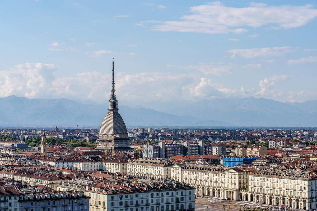 La cálida luz del atardecer  ilumina los edificios históricos de Turín, entre los cuales destaca la impresionante Mole Antonelliana. 