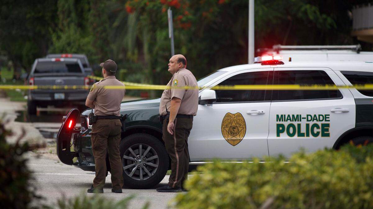 Two Miami-Dade Police officers at the scene where a suspect was shot and killed in Miami Springs on Tuesday, August 16, 2022.