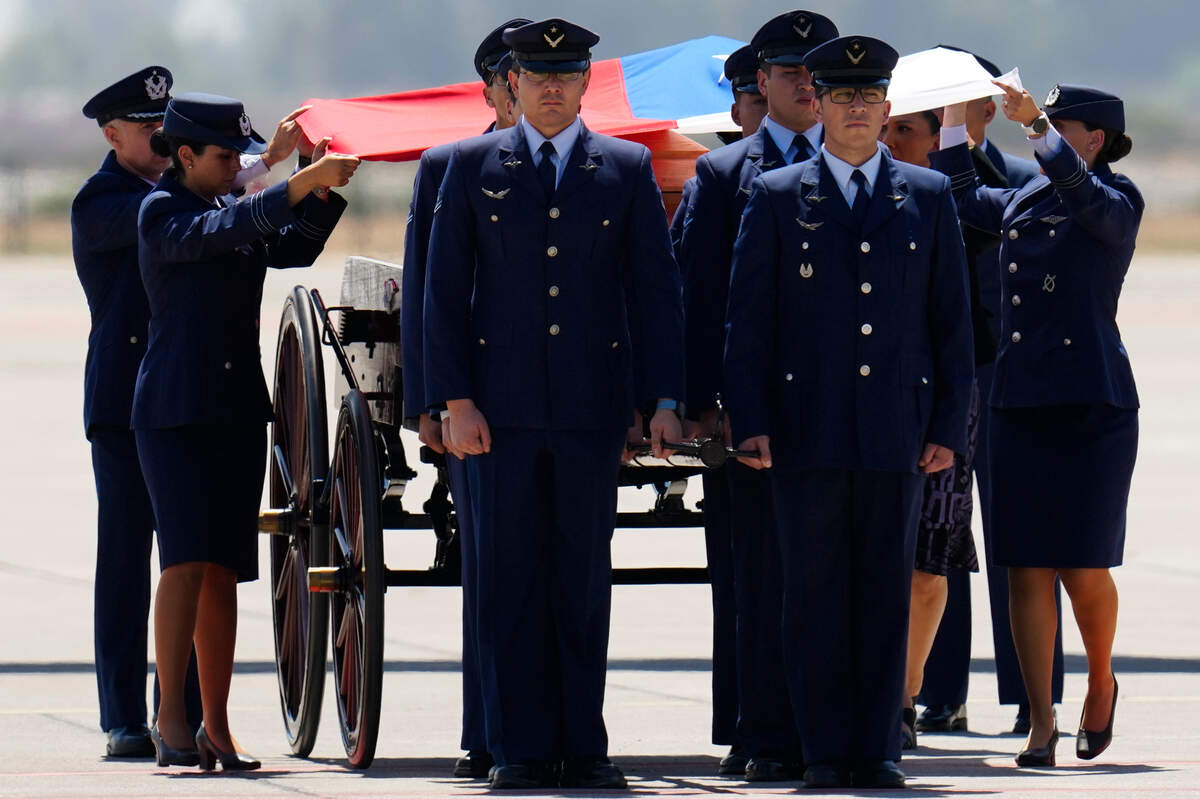Miembros de las fuerzas armadas cubren con la bandera de Chile el féretro del expresidente Sebastián Piñera, en Santiago, el miércoles 7 de febrero de 2024. Piñera falleció el martes 6 de febrero de 2024 a los 74 años en un accidente de helicóptero.