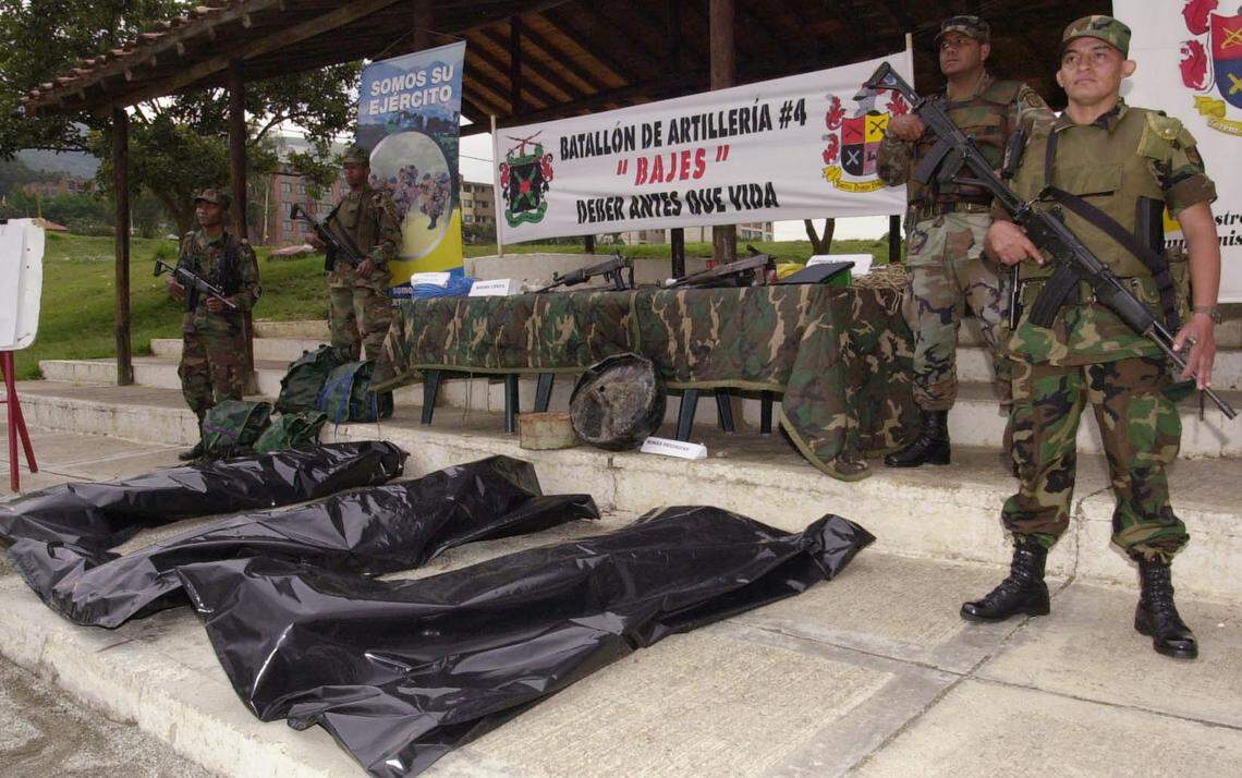 Soldados colombianos junto a los cadáveres de tres guerrilleros del Ejército de Liberación Nacional (ELN), en una base militar en Bello, al norte de Medellín, en septiembre del 2003. Los rebeldes fueron abatidos en enfrentamientos con fuerzas del gobierno.