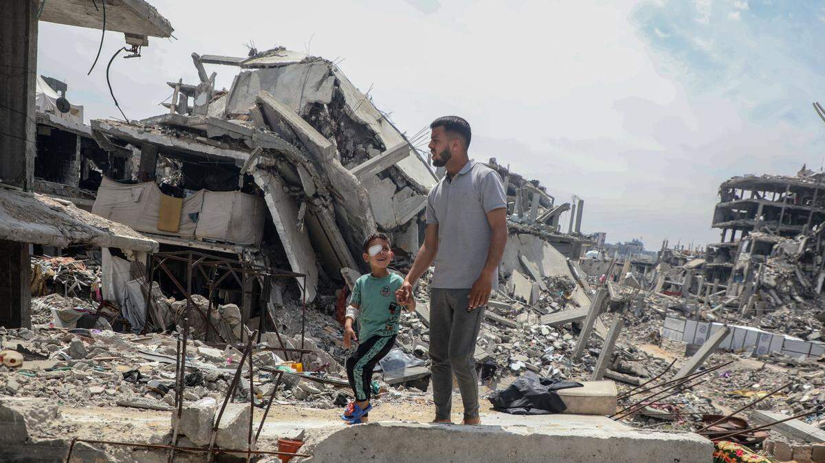 Un niño palestino que perdió un ojo a causa de un explosivo israelí camina con su padre por una vivienda destruida, el martes 29 de abril de 2025, en el pueblo de Beit Lahia, en el norte de la Franja de Gaza.